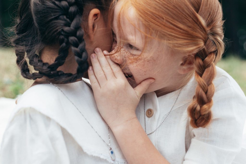 Two Young Girls Telling Secrets